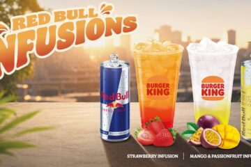 Napoje Red Bull Infusions w Burger King – truskawkowy oraz mango z marakują, podane obok puszek Red Bulla